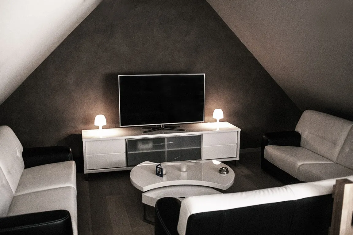 Lounge met witte zetels en televisie