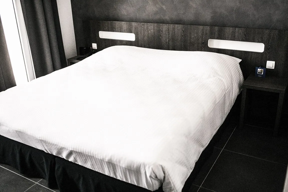 Kleine tweepersoonskamer met wit beddengoed